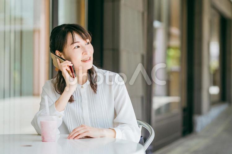 カフェで電話をするビジネスウーマン カフェ,スマホ,電話の写真素材