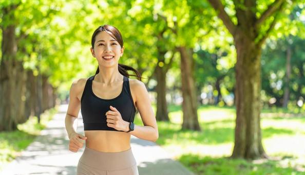 夏の公園でジョギングする若い日本人女性 夏の公園でジョギングする若い日本人女性の写真