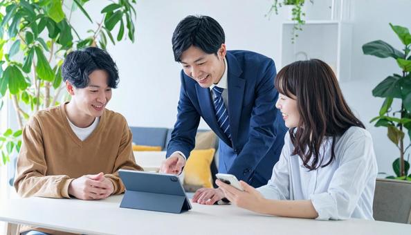 タブレットを使って説明する男性営業マンの写真