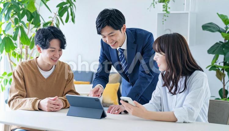 タブレットを使って説明する男性営業マン タブレット,男性営業マン,男性ビジネスマンの写真素材