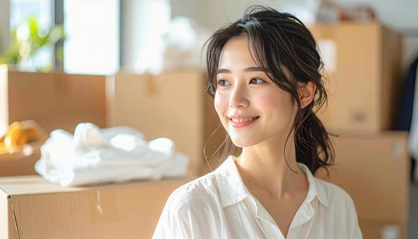 明るい部屋で断捨離を楽しむ女性の写真