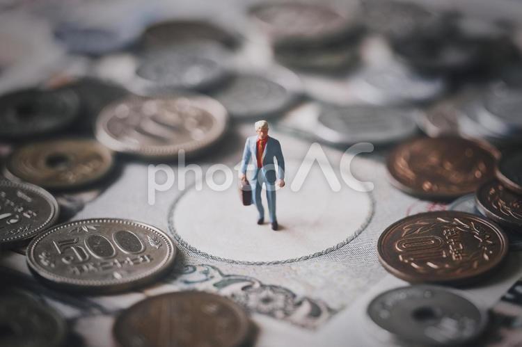 ミニチュアのビジネスマンとお金 ビジネス,硬貨,背景の写真素材