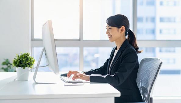 パソコンで仕事する女性会社員 スーツ パソコンで仕事する女性会社員 スーツの写真