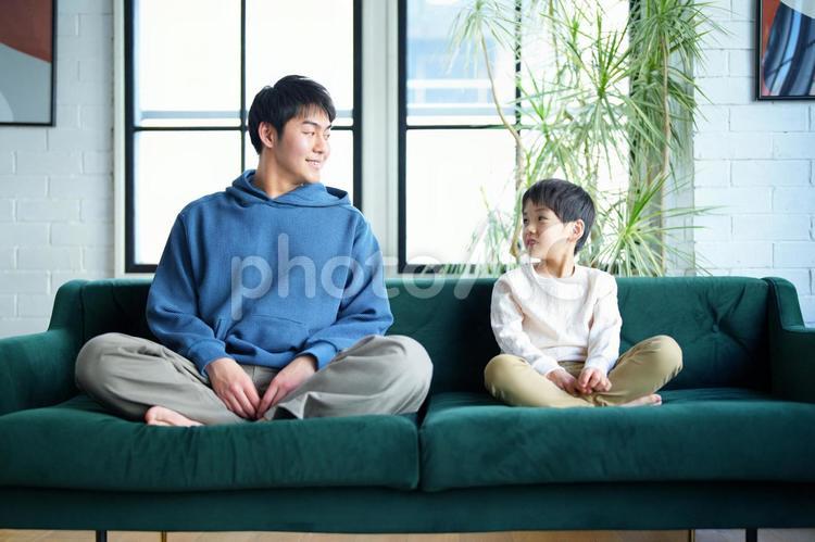 ソファーに座って見つめる親子 親子,男の子,小学生の写真素材