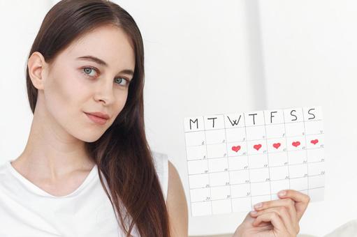 月経期間を示すカレンダーを手に持っている女性 生理,月経,女性の写真素材