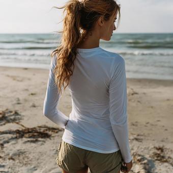 夕暮れの砂浜に立つ女性の後ろ姿 夕暮れの砂浜に立つ女性の後ろ姿の写真