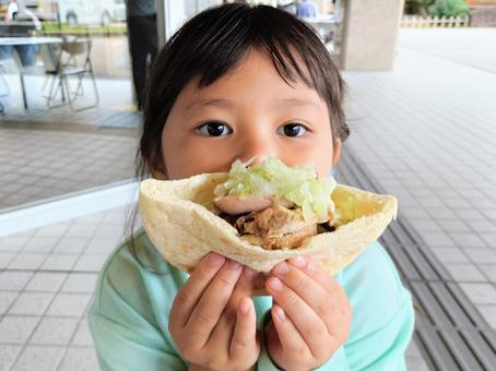 ケバブサンドを手に持つ女の子 ケバブサンドを手に持つ女の子 ケバブ,ケバブサンド,食べ歩きの写真素材