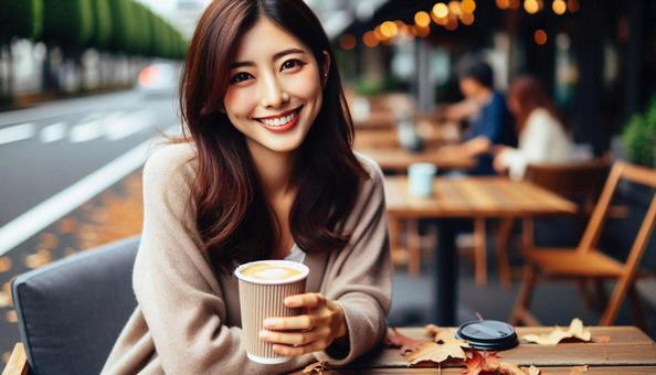秋　屋外カフェテラスで微笑む女性の写真