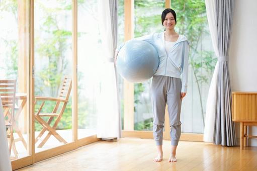 右手でバランスボールを抱えて持つ女性 女性,日本人,バランスボールの写真素材