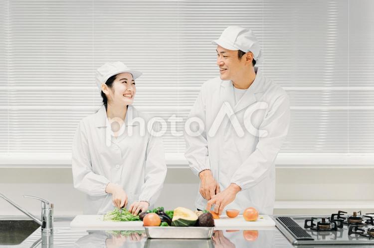 食品工場・スーパーで働く男女の調理員 食品工場,給食センター,調理師の写真素材