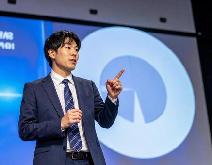 ステージ上で堂々とプレゼンする男性 ステージ上で堂々とプレゼンする男性の写真