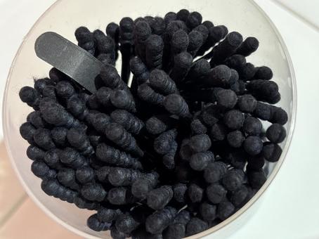 ケースに詰まった黒い綿棒 ケースに詰まった黒い綿棒の写真
