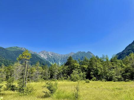 広大な草原と穂高連峰の絶景 広大な草原と穂高連峰の絶景 穂高連峰,上高地,自然の写真素材