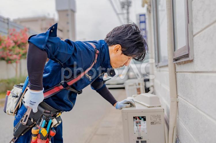 エアコン室外機の内部を点検する電気工事士 ビジネス,ビジネスマン,男の写真素材
