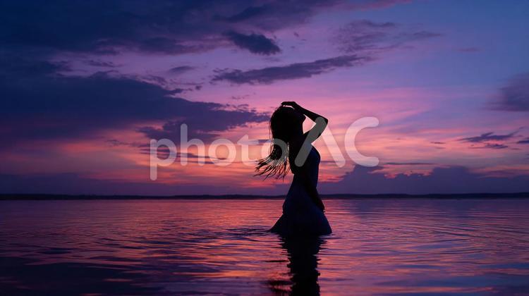 水中で迎える美しい夕暮れ 女性,シルエット,海の写真素材