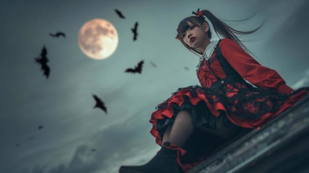 満月に座る吸血鬼少女の写真