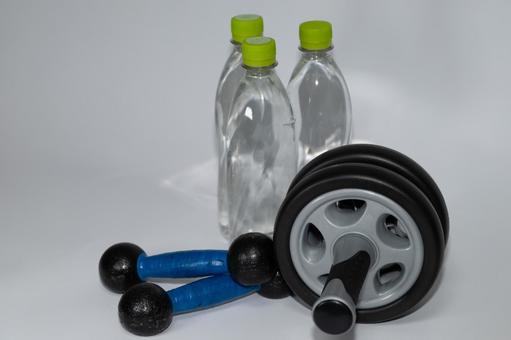 自宅トレーニングと水分補給のセット トレーニング,ダンベル,腹筋ローラーの写真素材