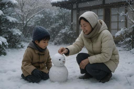 雪だるまを作る親子 雪だるまを作る親子の写真