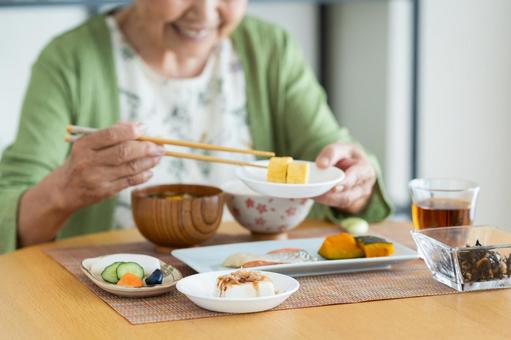 朝食を食べるシニアの女性 朝食を食べるシニアの女性の写真