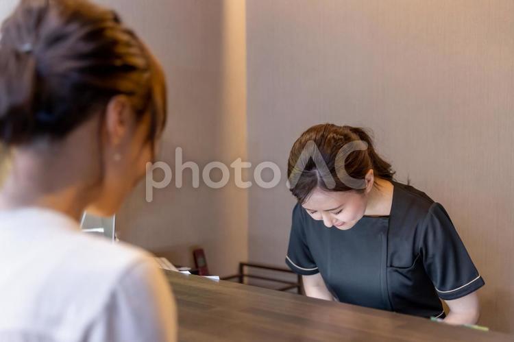 美容外科で施術を受ける女性（お辞儀） いらっしゃいませ,お辞儀,受付の写真素材