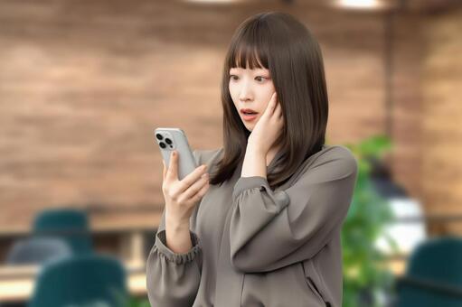 スマホの画面を見て驚くビジネスウーマン 女性,スマホ,スマートフォンの写真素材
