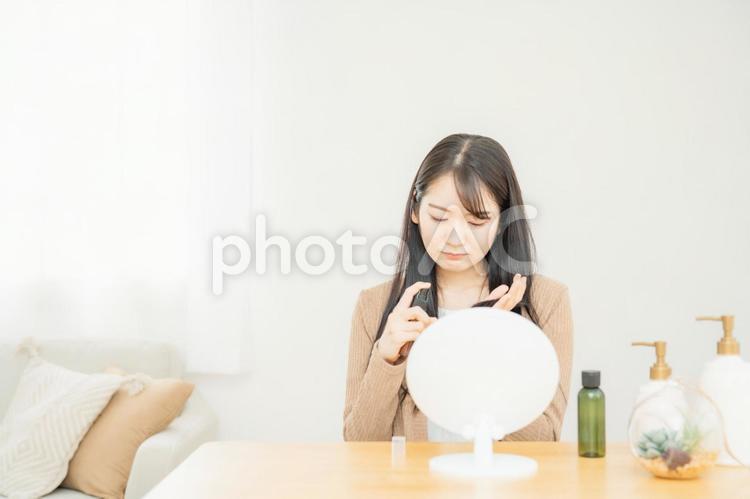 ヘアケア商品を使う女性（困る） ダメージヘア,寝ぐせ,寝癖の写真素材