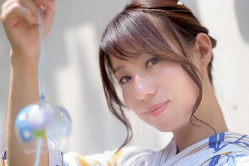 風鈴を持った浴衣を着た女性 風鈴を持った浴衣を着た女性 風鈴,浴衣,夏の風物詩の写真素材