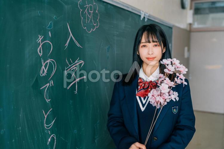 嬉しそうに桜の花をもつ新入生 女性,女子高生,高校生の写真素材
