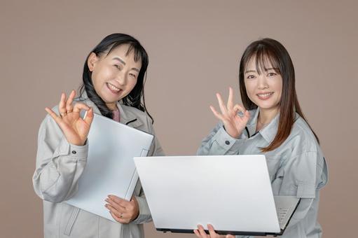 パソコンと作業員女性2人 パソコンと作業員女性2人 女性,作業服,パソコンの写真素材