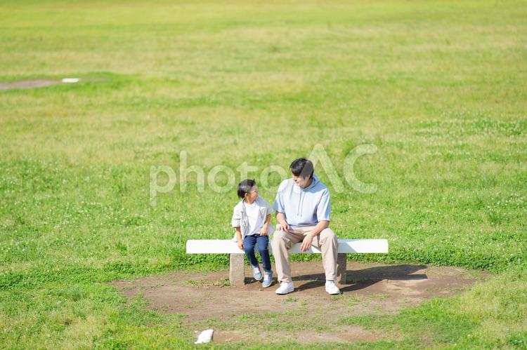ベンチで話している父と息子 親子,ベンチ,座るの写真素材