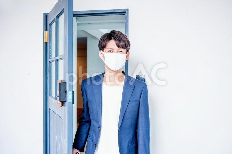 ドアから入ってくるマスク姿の男性 マスク,男性,コロナの写真素材