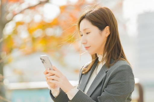紅葉の街路樹と女性・ビジネスウーマン 女性,秋,紅葉の写真素材
