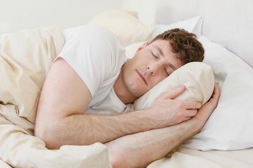 ベッドで横向きで眠る男性 男性,外国人,欧米人の写真素材