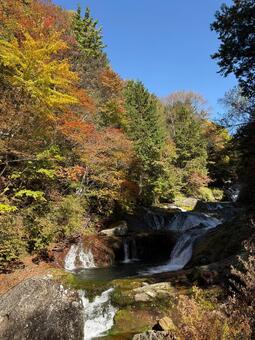 紅葉に包まれた滝と青空の秋景色 紅葉,滝,秋の写真素材