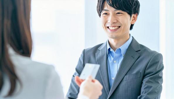 笑顔で名刺交換をする男性会社員の写真