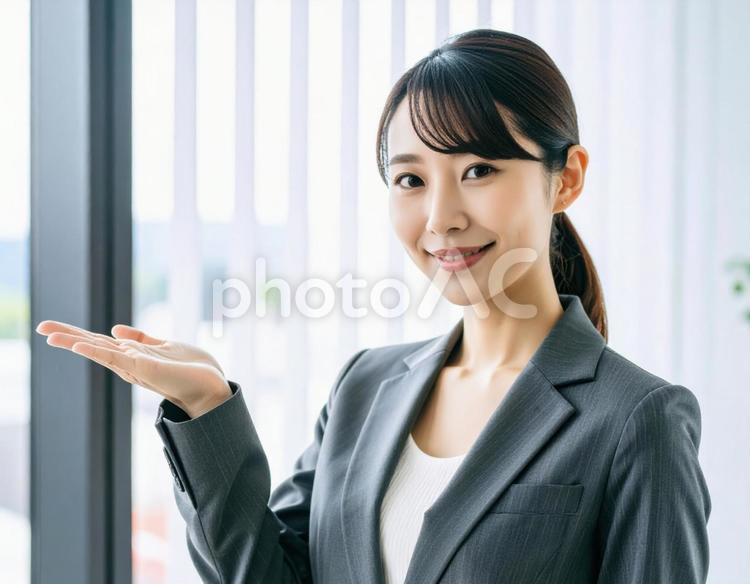案内ポーズをするスーツ姿の女性 女性,ビジネス,スーツの写真素材