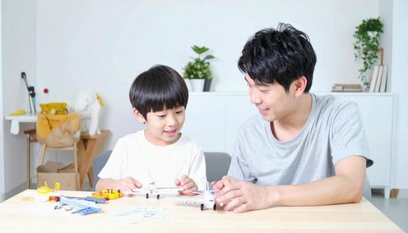 父親と一緒にプラモデルを作る男の子 父親と一緒にプラモデルを作る男の子の写真