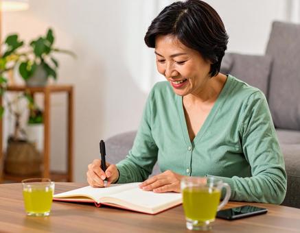 テキストを開きノートに書く日本人女性 テキストを開きノートに書く日本人女性の写真