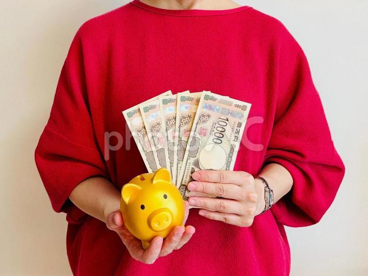 浪費家でも貯金できる！と説明する女性 貯金箱,積立,貯金の写真素材