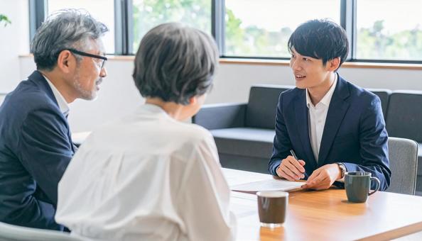 シニア夫婦と営業マン シニア夫婦と営業マンの写真