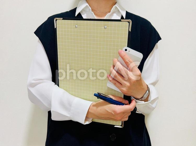 仕事中・バインダーとスマホを持った女性 点検,調査,調査員の写真素材