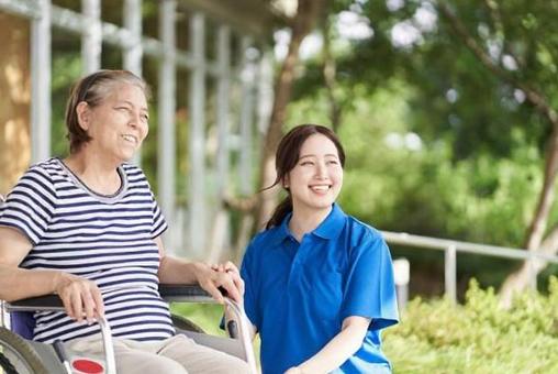 坐輪椅的老人和女性看護人 坐輪椅的老人和女性看護人