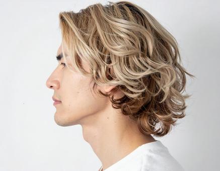ブロンドパーマヘアの男性横顔 ブロンドパーマヘアの男性横顔の写真