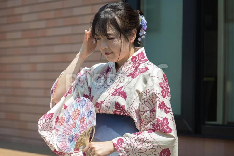頭を押える浴衣女性 頭痛,熱中症,体調不良の写真素材
