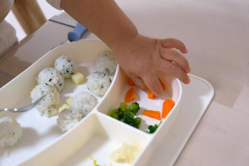 幼児食のにんじんを手づかみ食べする子ども 子ども,幼児食,手づかみの写真素材