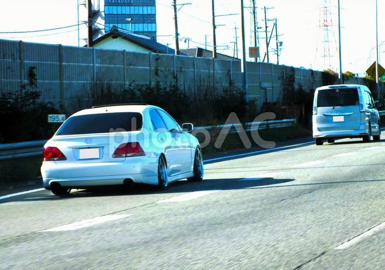 たくさんの鉄塔が並び立つ高速道路と白い車 車,ドライブ,高速道路の写真素材