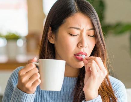 薬を飲む女性 薬を飲む女性の写真