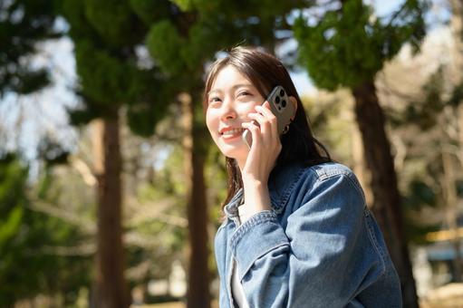 公園で電話をする女性 公園で電話をする女性 スマホ,女性,ビジネスの写真素材