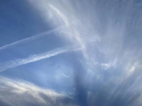 飛行機雲と広がる雲 飛行機雲と広がる雲の写真