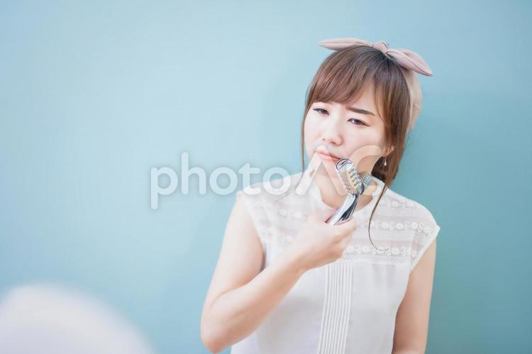美顔ローラーを使う女性 顔痩せ,顔ダイエット,小顔の写真素材